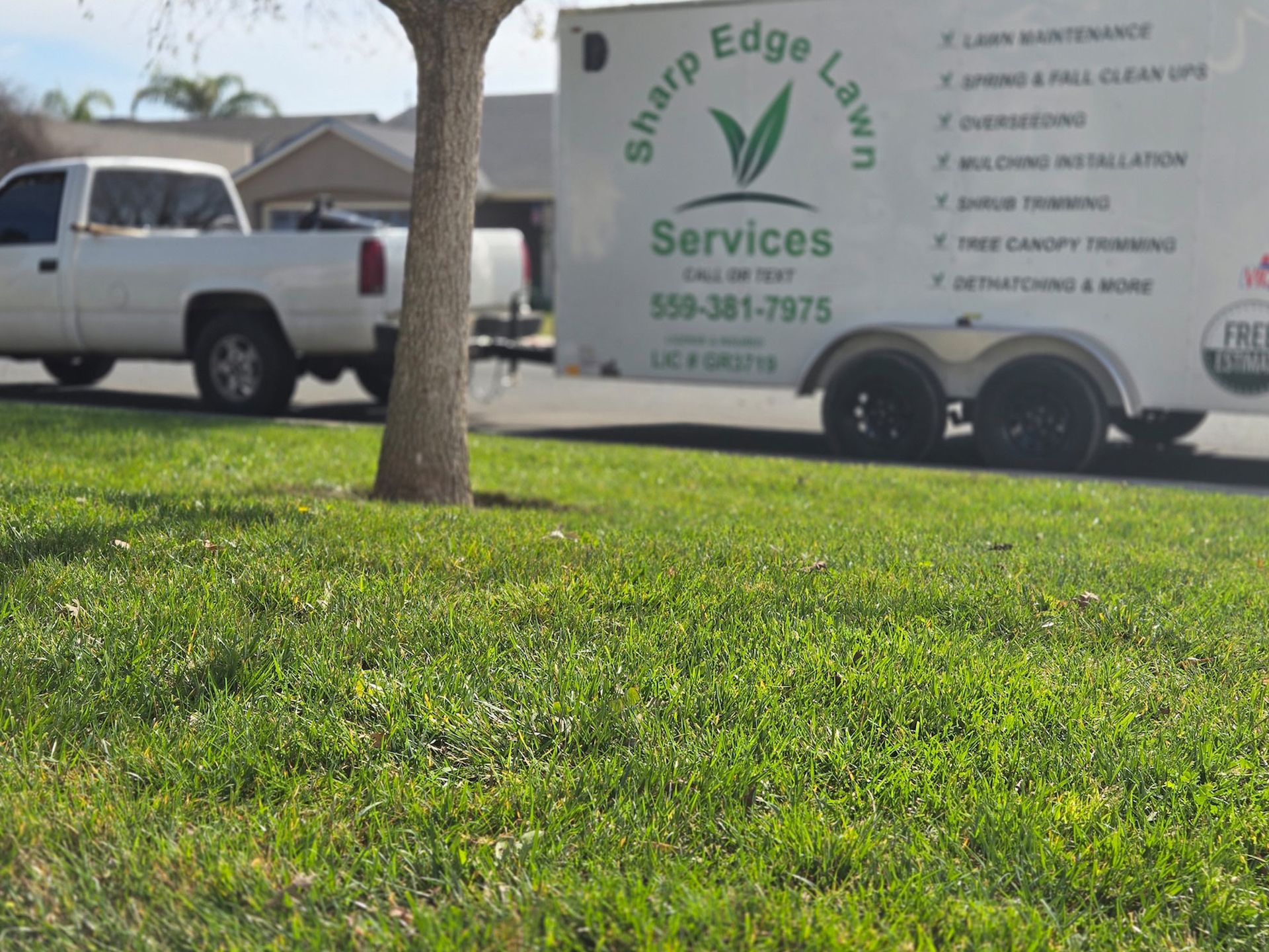 A white truck with a trailer advertising 