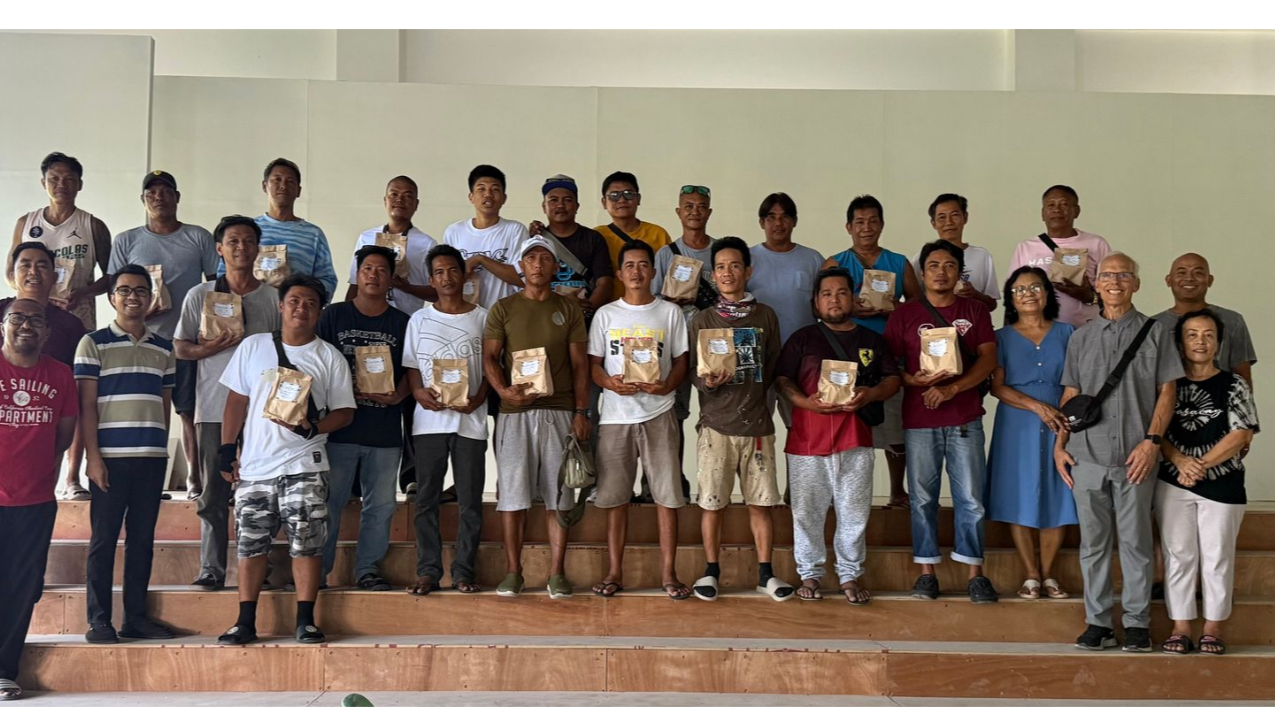 Group of people posing on a stage, many holding awards, in a bright indoor hall