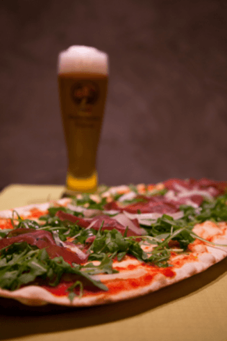 pizza con birra sullo sfondo