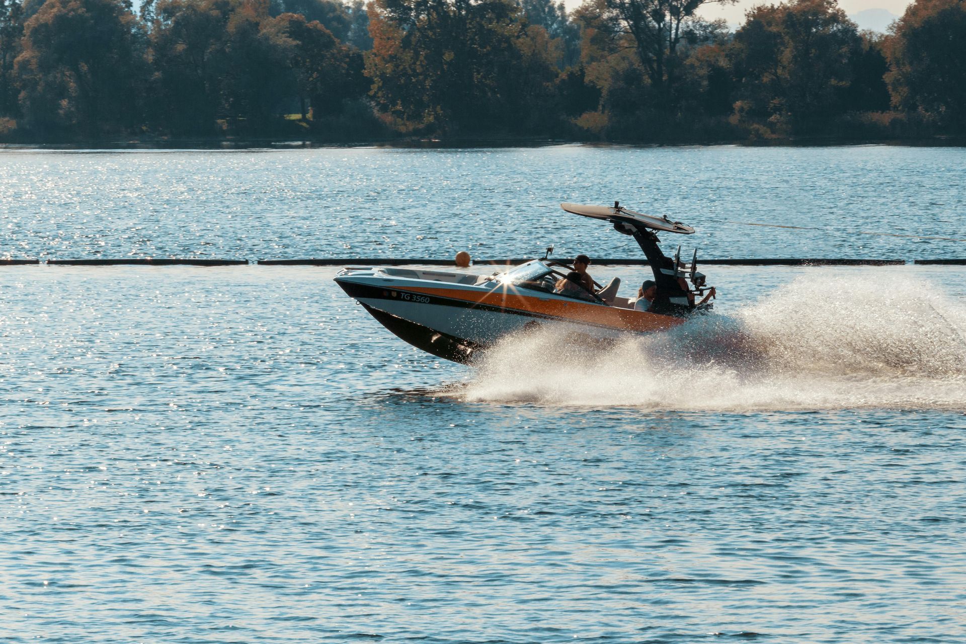 Motorboat speeding across Hayden Lake, creating a spray of water.