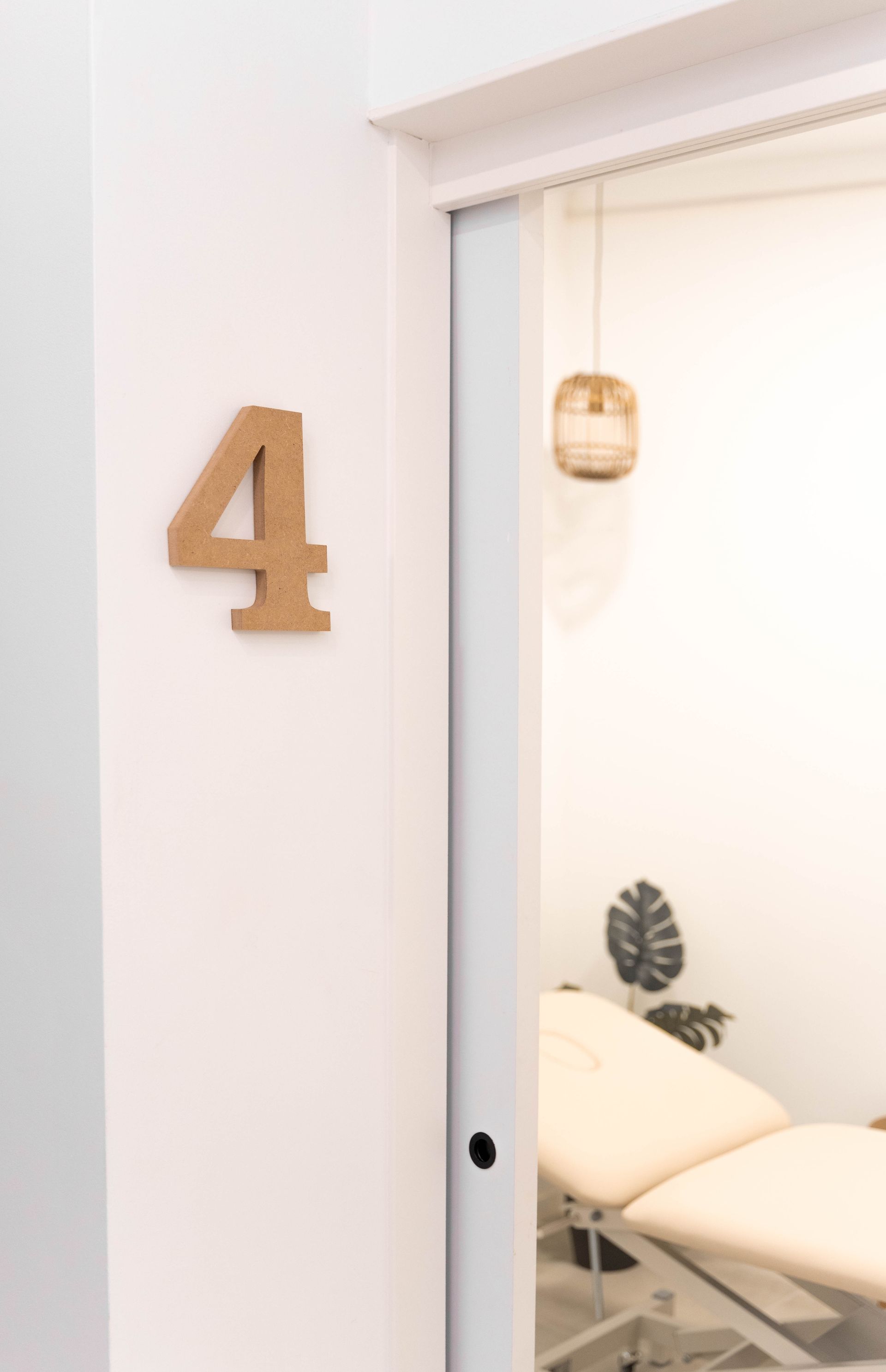 Una habitación con una cama y un número cuatro en la pared.