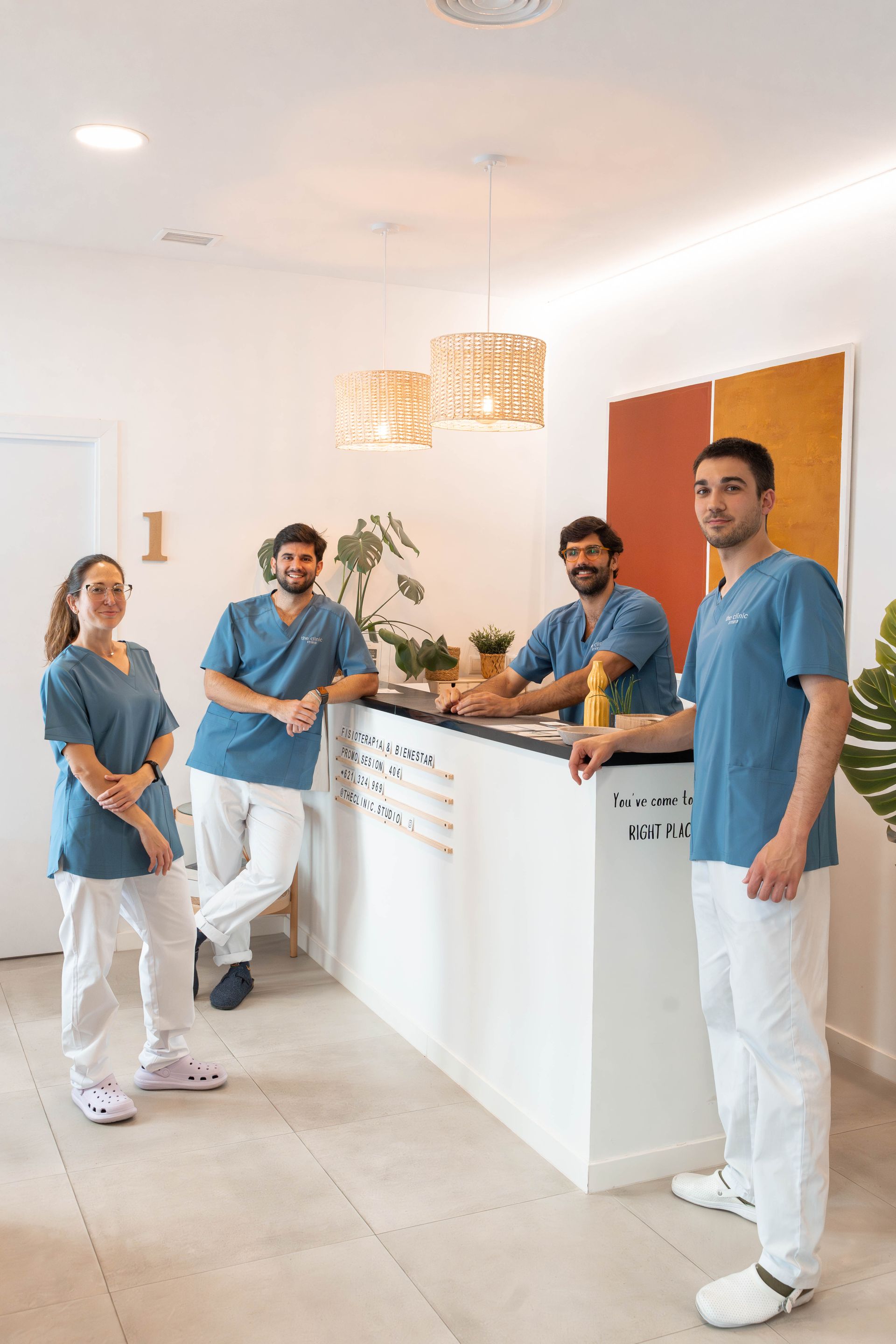 Un grupo de dentistas está parado frente a un mostrador en un consultorio dental.