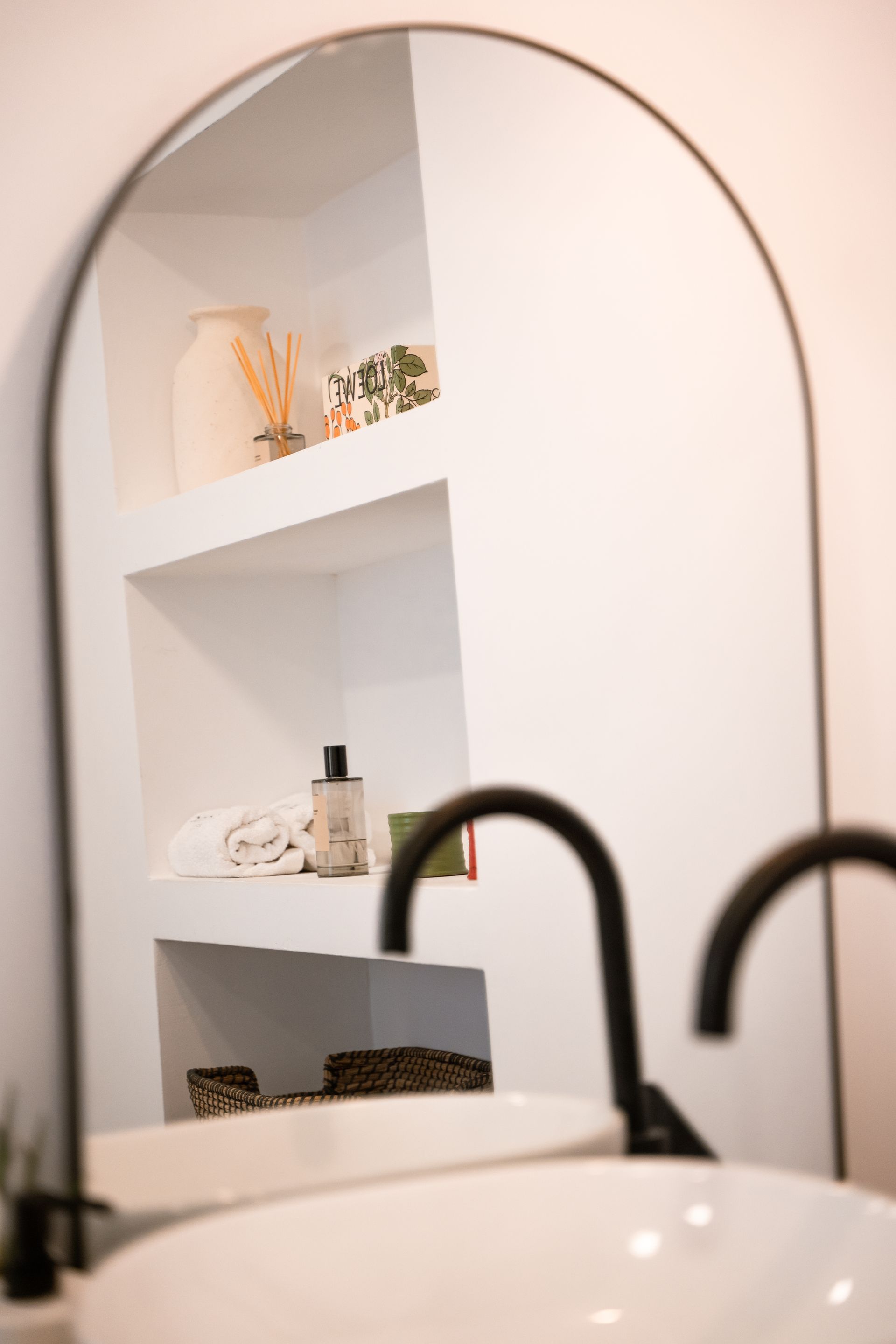 Un baño con lavabo y espejo con marco negro.