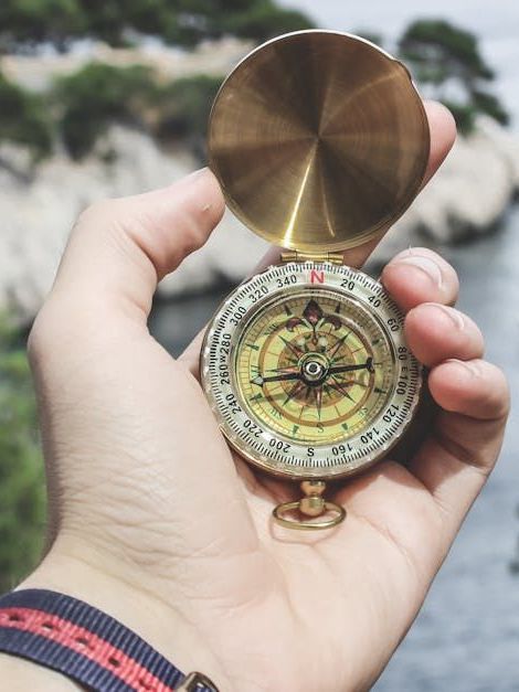 A person is holding a compass in their hand.