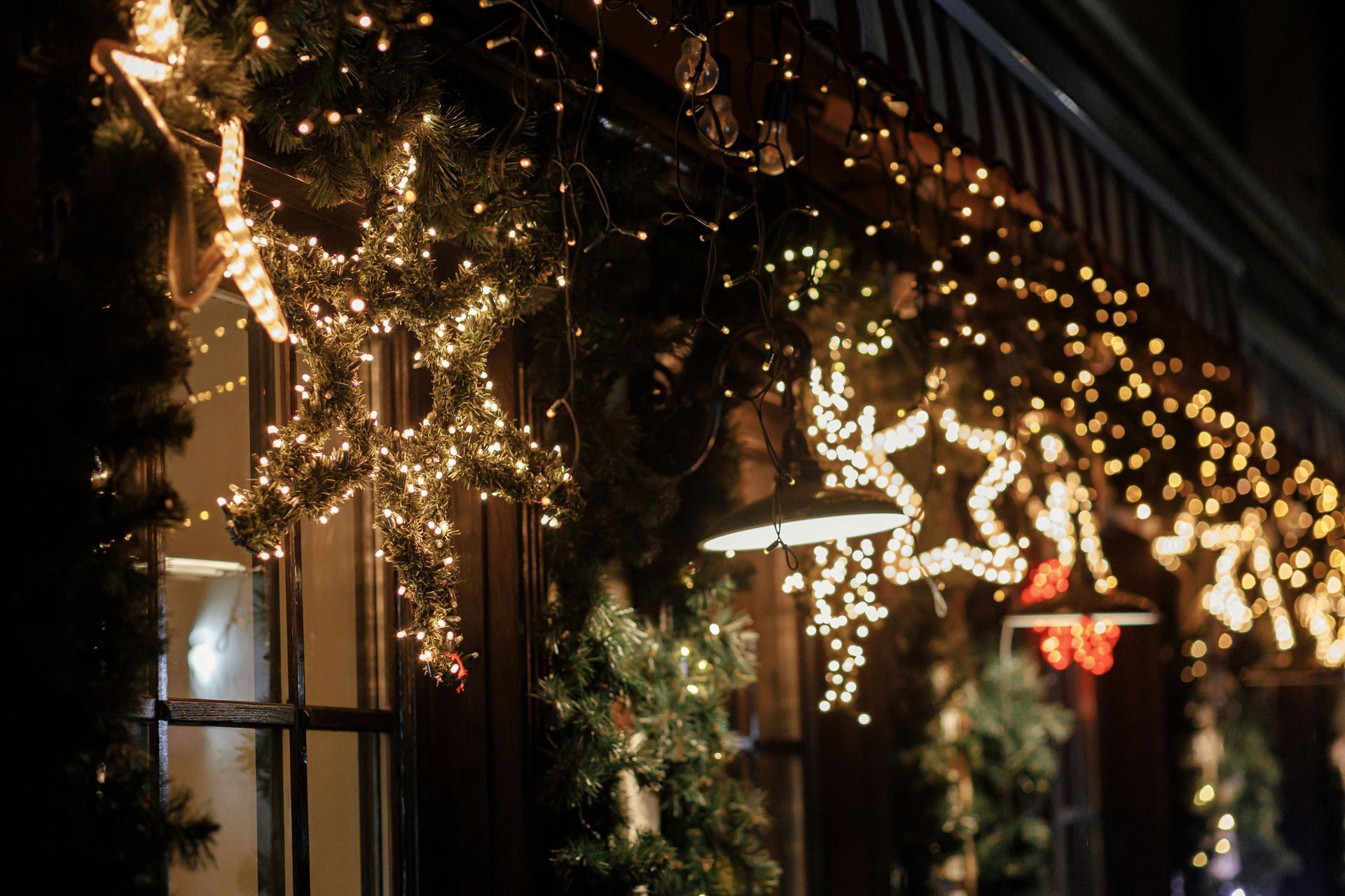 A building is decorated with christmas lights and decorations at night.