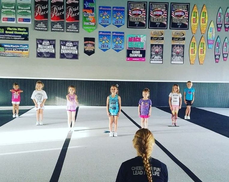A group of young girls are practicing gymnastics in a gym