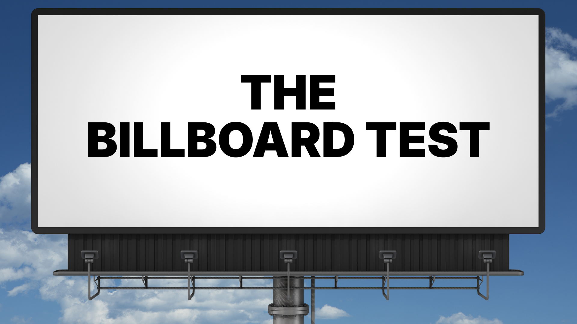 Billboard reading “THE BILLBOARD TEST” on a gray sign against a blue sky.