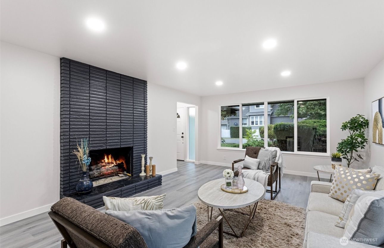 An empty living room with hardwood floors and a fireplace