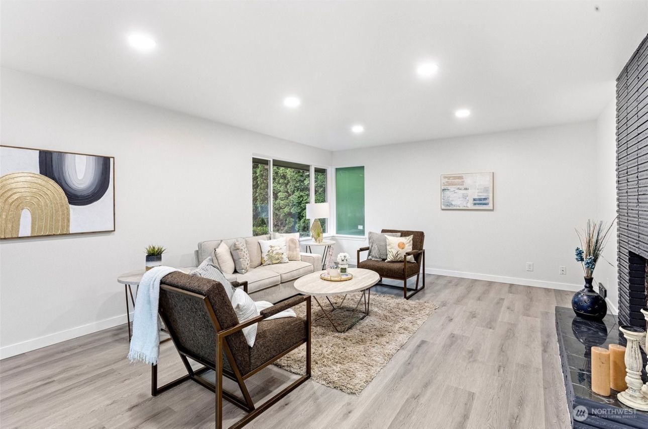 A living room with a couch , chairs , coffee table and fireplace