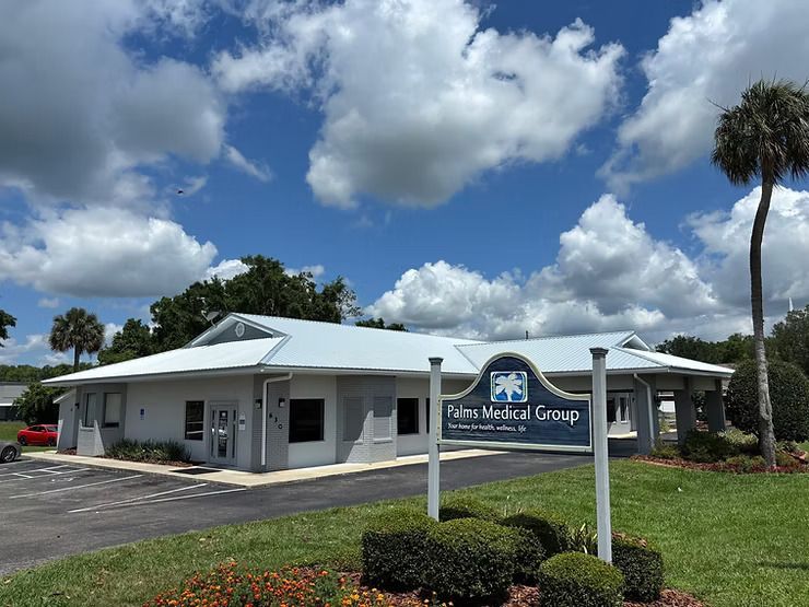 Exterior of Elite Medical Group building under a partly cloudy blue sky, with sign on the lawn.