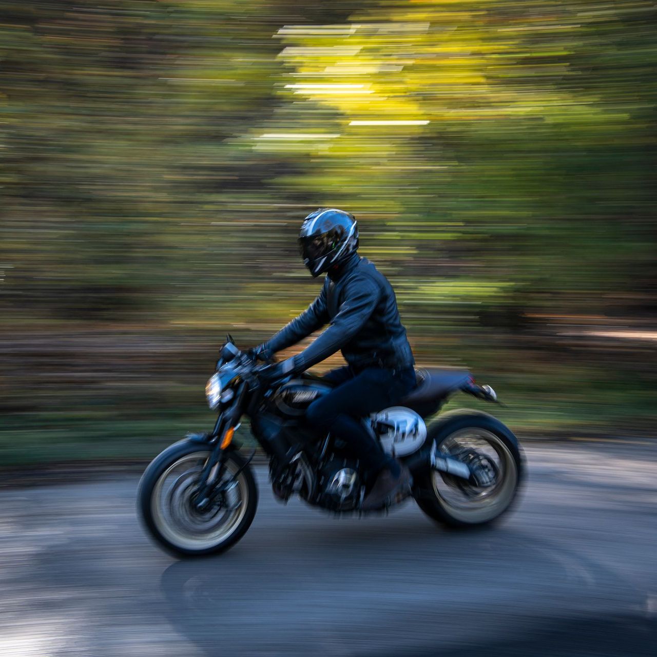 A man is riding a motorcycle down a road.