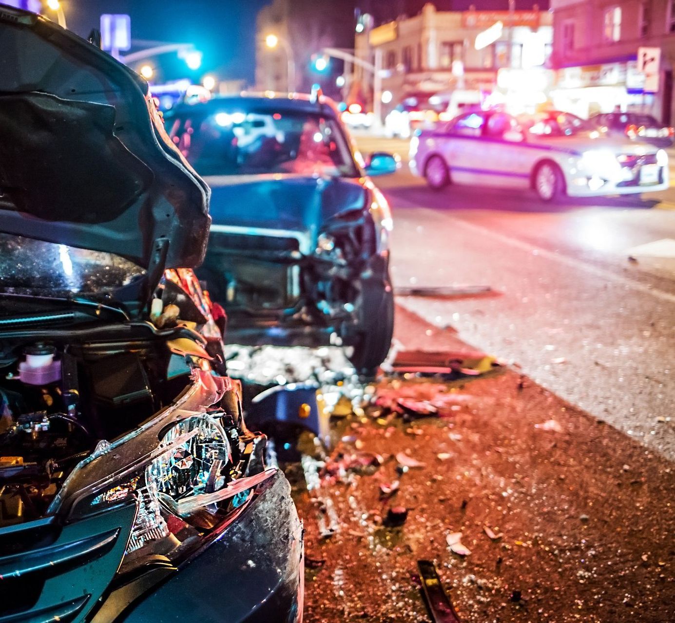 A car with its hood open is parked on the side of the road.