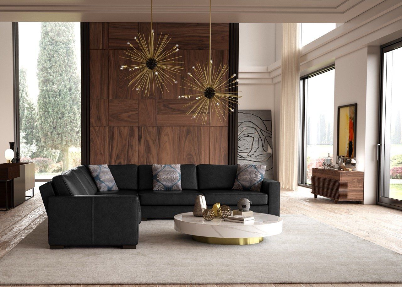 A living room with a black sectional couch and a white coffee table.