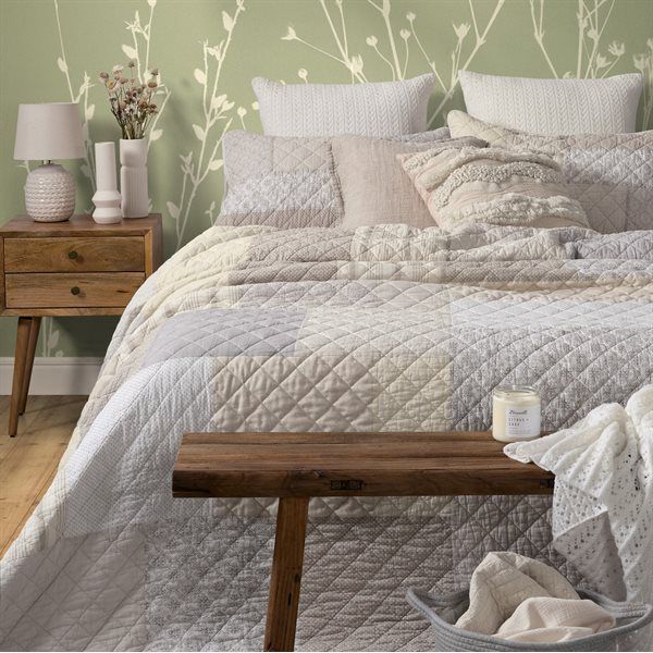 Bedroom with patchwork quilt, nightstand, and bench