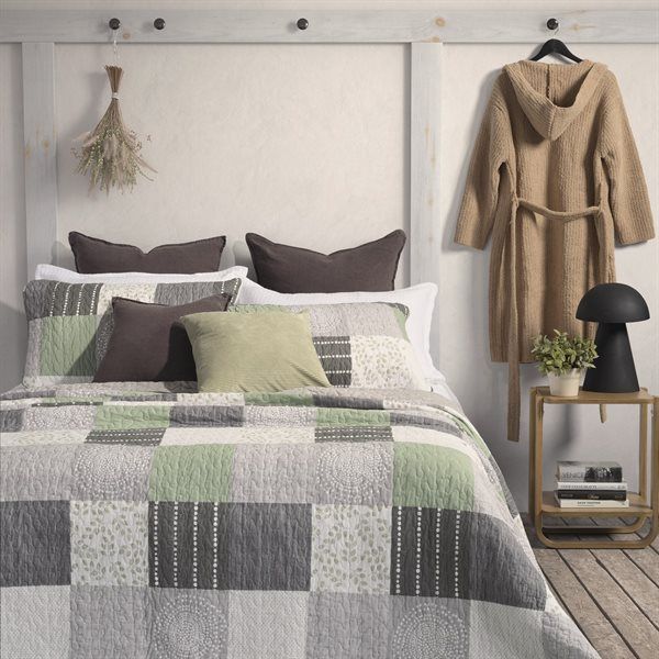 Bedroom with Green, gray, and white tones patchwork quilt, throw pillows, robe