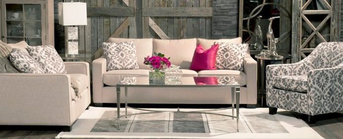 A living room with a white couch , chair , coffee table and rug.