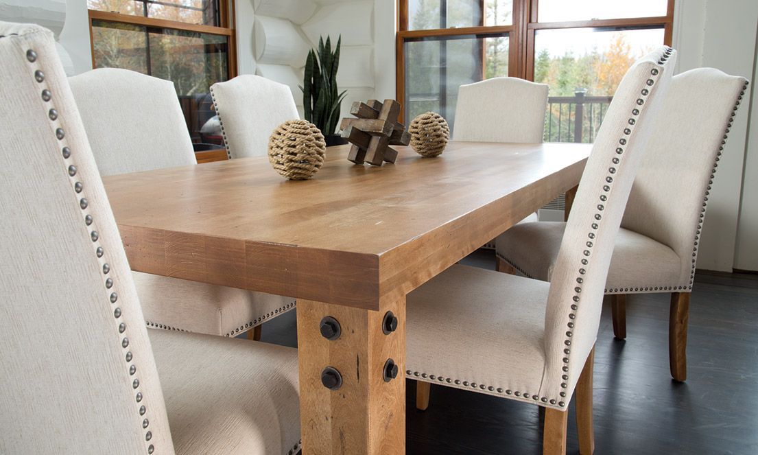 wooden dining table with six white upholstered chairs