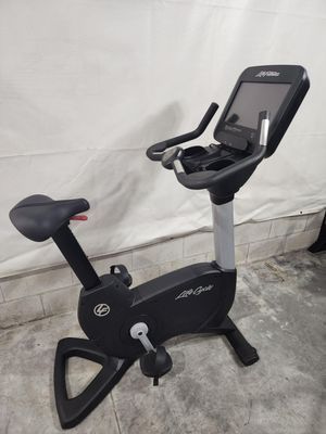 A black exercise bike is sitting on a concrete floor.