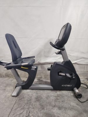 A black and silver recumbent exercise bike is sitting on a concrete floor.