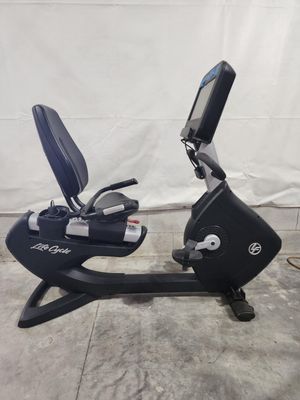 A black exercise bike is sitting on a concrete floor.