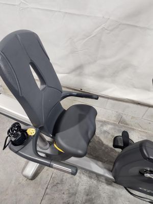 A recumbent exercise bike is sitting on a concrete floor.