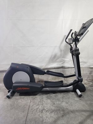 An elliptical machine is sitting on top of a concrete floor.