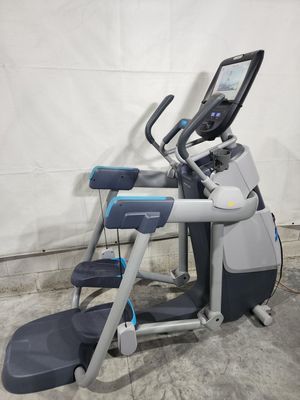 A gray and blue elliptical machine is sitting on a concrete floor.