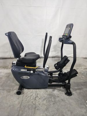 A recumbent exercise bike is sitting on top of a concrete floor.
