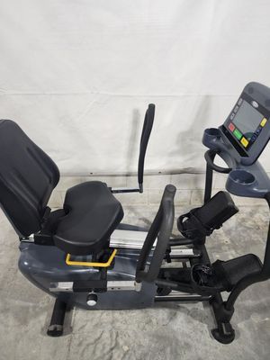 A recumbent exercise bike is sitting on top of a concrete floor.