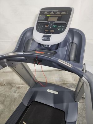 A treadmill is sitting on a concrete floor in a garage.