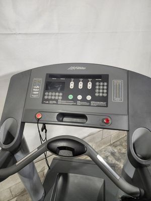 A treadmill is sitting on top of a wooden floor.