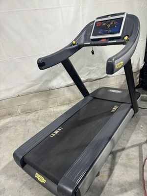 A treadmill is sitting on a concrete floor in a room.