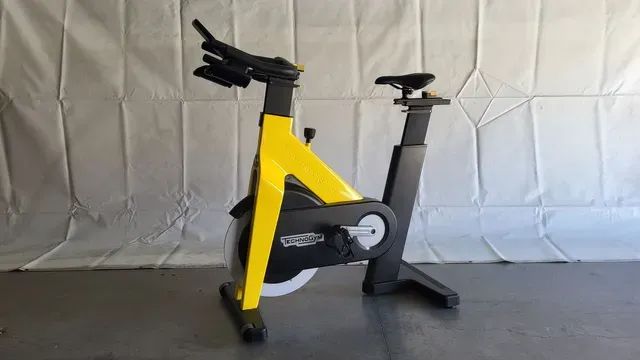 A yellow and black exercise bike is sitting on a table.