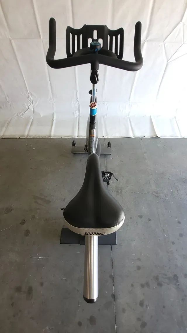 An exercise bike is sitting on a concrete floor in a garage.