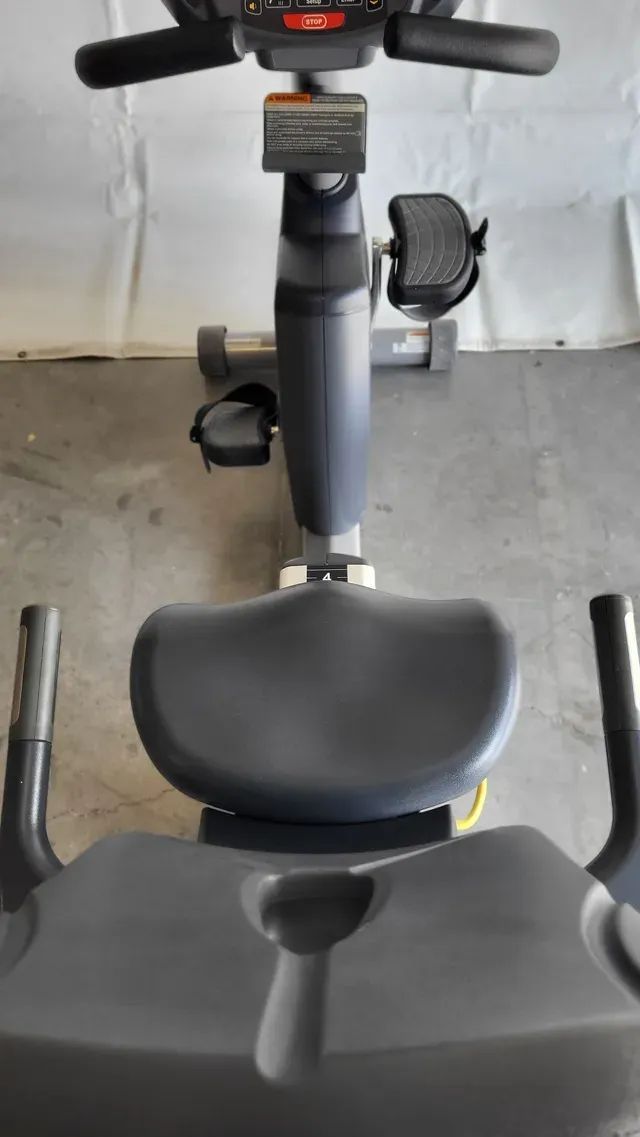 A close up of a recumbent exercise bike in a gym.