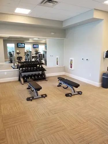 A gym with a lot of dumbbells and benches.