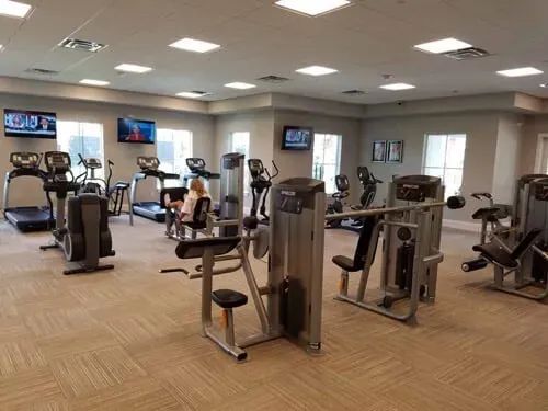 A large gym filled with lots of exercise equipment.