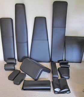 A bunch of black pieces of furniture are sitting on a carpet.
