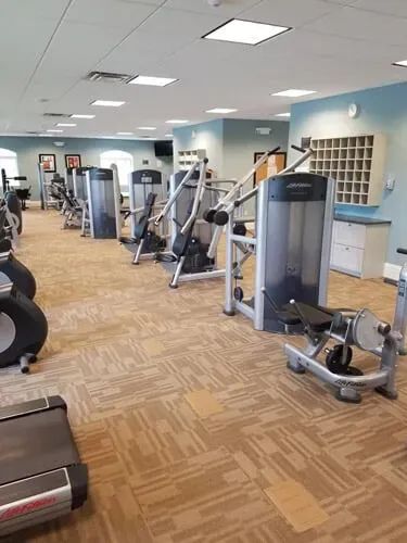 A large gym filled with lots of exercise equipment.