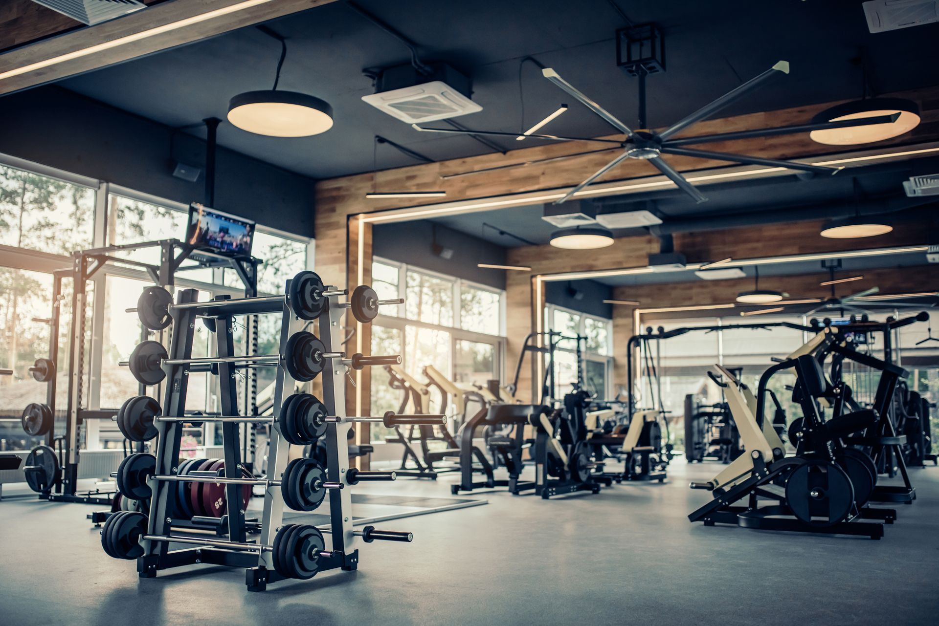 A Gym Filled With Lots of Exercise Equipment and a Ceiling Fan