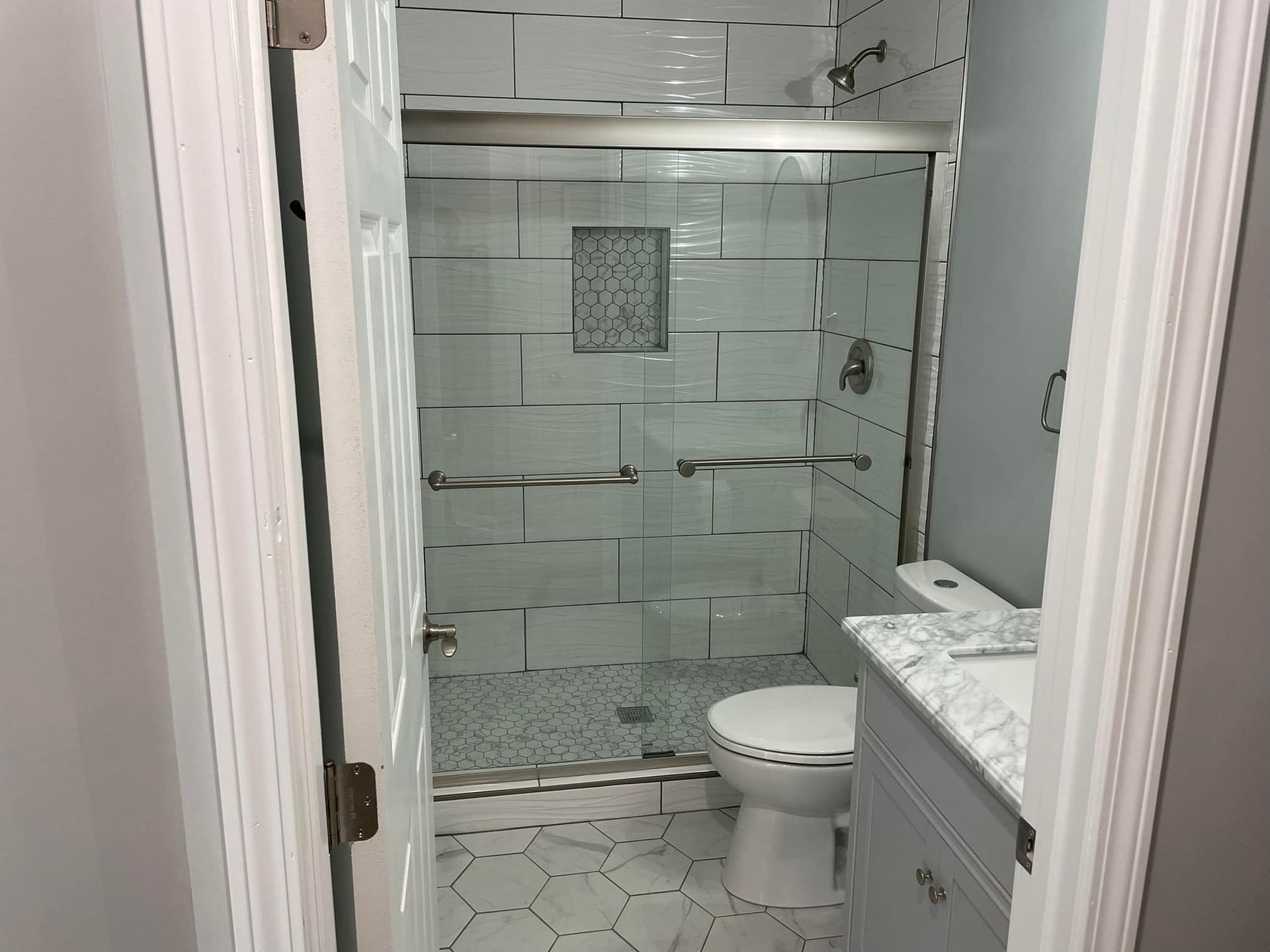 A bathroom with a toilet and a walk in shower