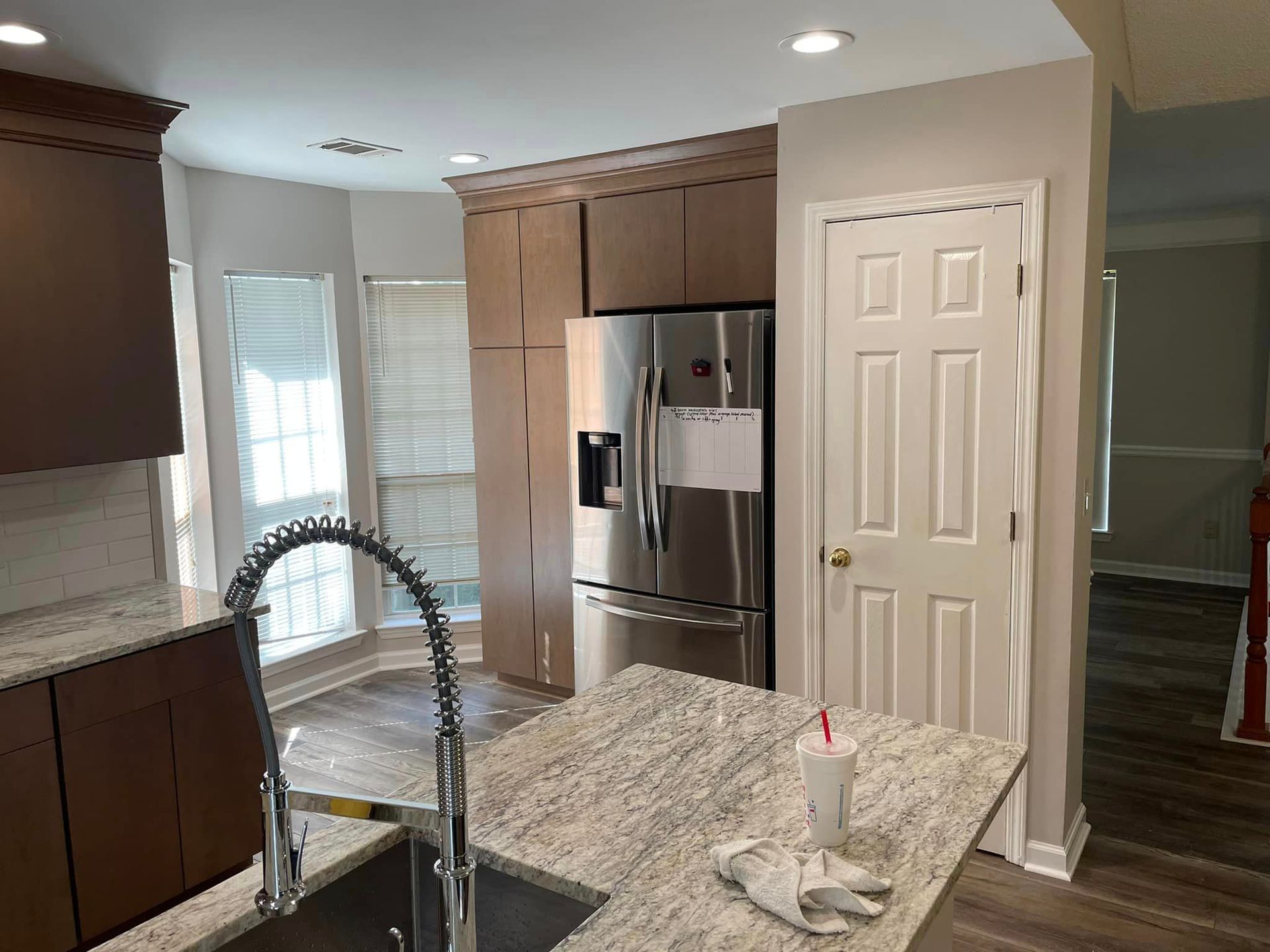 A kitchen with stainless steel appliances , granite counter tops , a sink and a refrigerator.