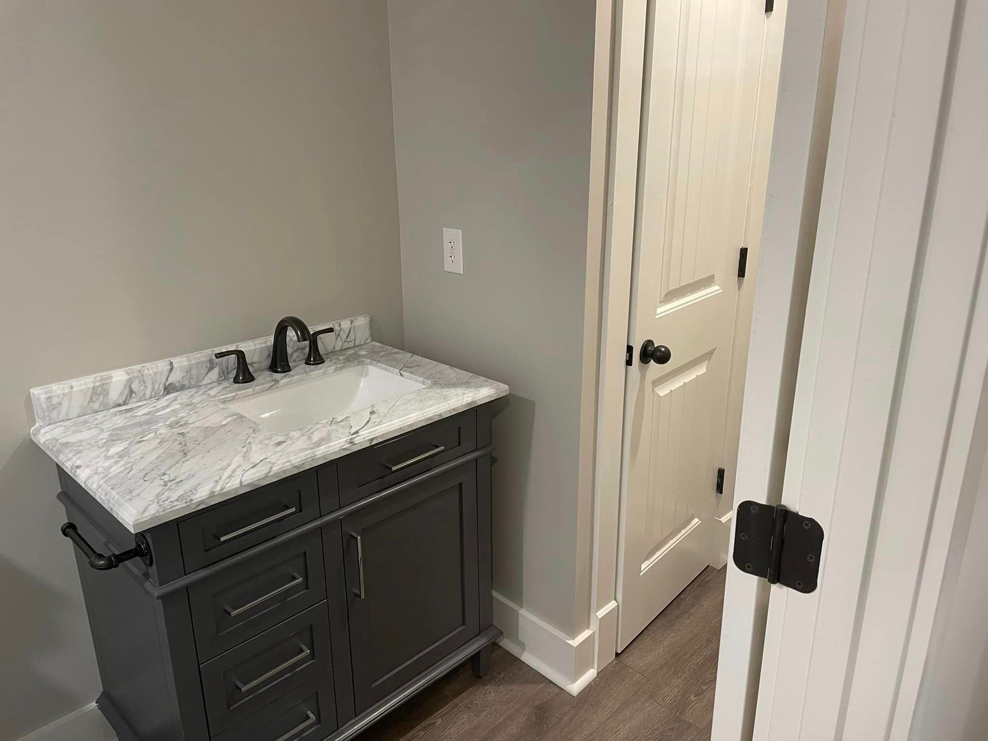 A bathroom with a sink and a door.