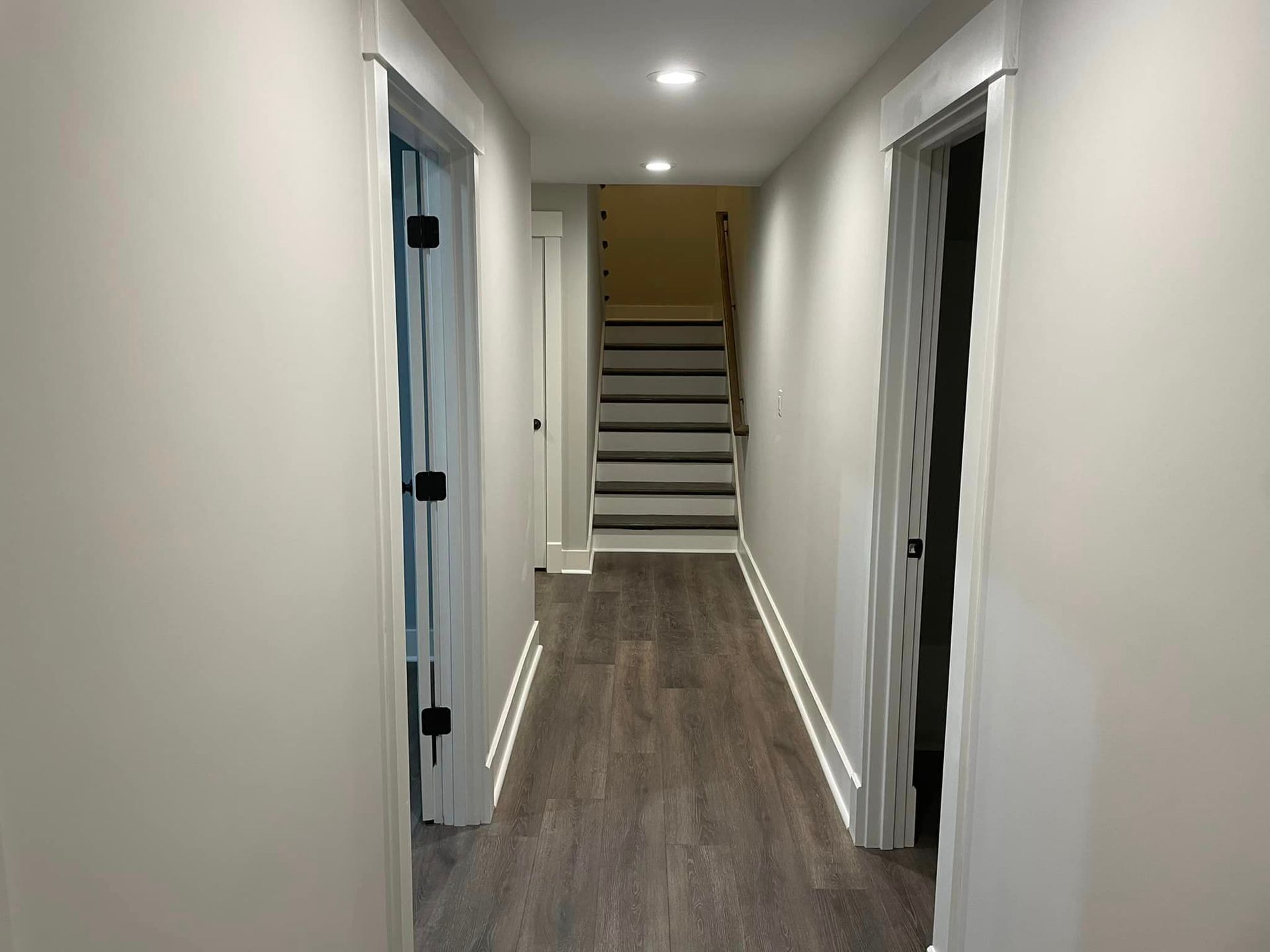 A long hallway with stairs leading up to the second floor