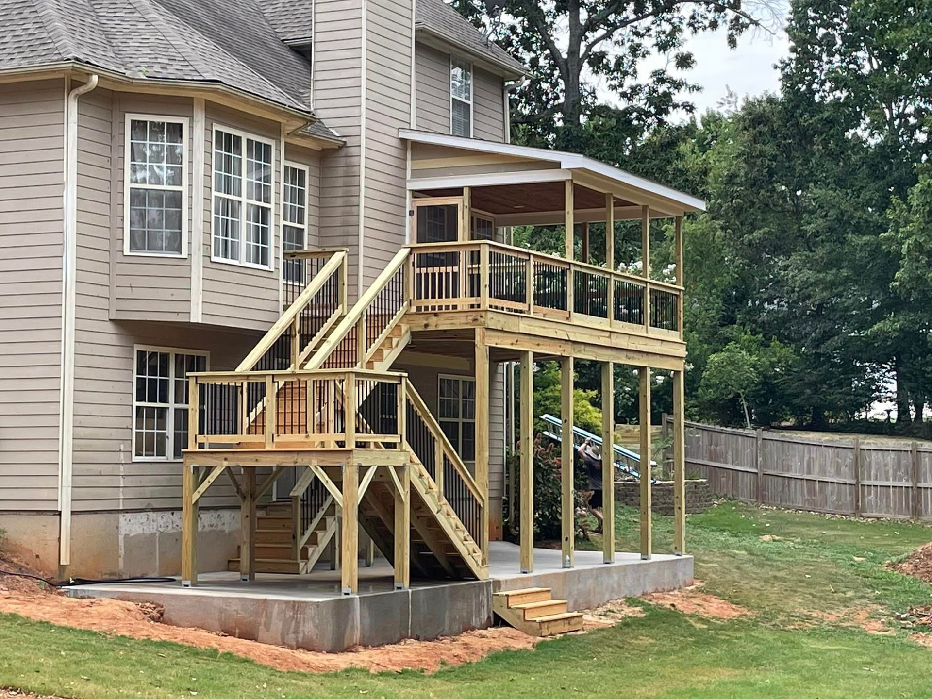 The back of a house with a wooden deck and stairs