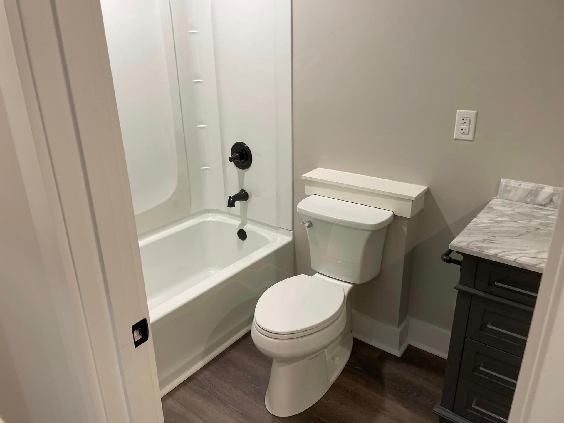 A bathroom with a toilet , bathtub and sink.