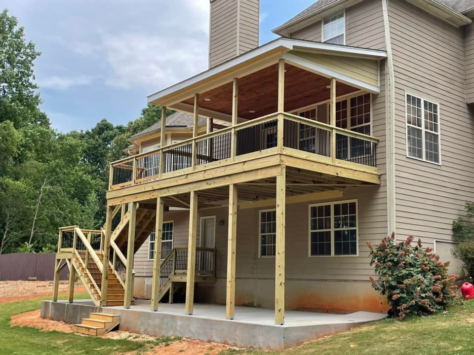 A house with a large wooden deck attached to it.