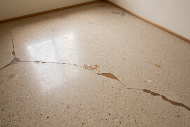 Terrazzo floor before repair — cracks, old coatings and surface damage visible