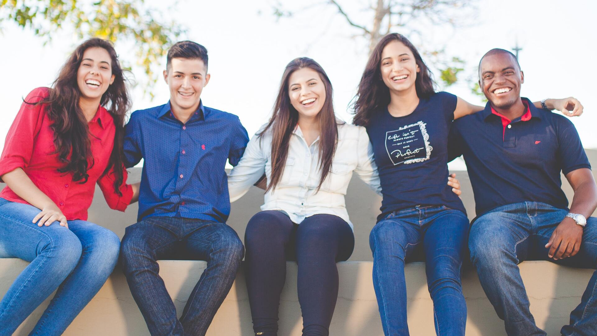 Group of friends smiling on a wall