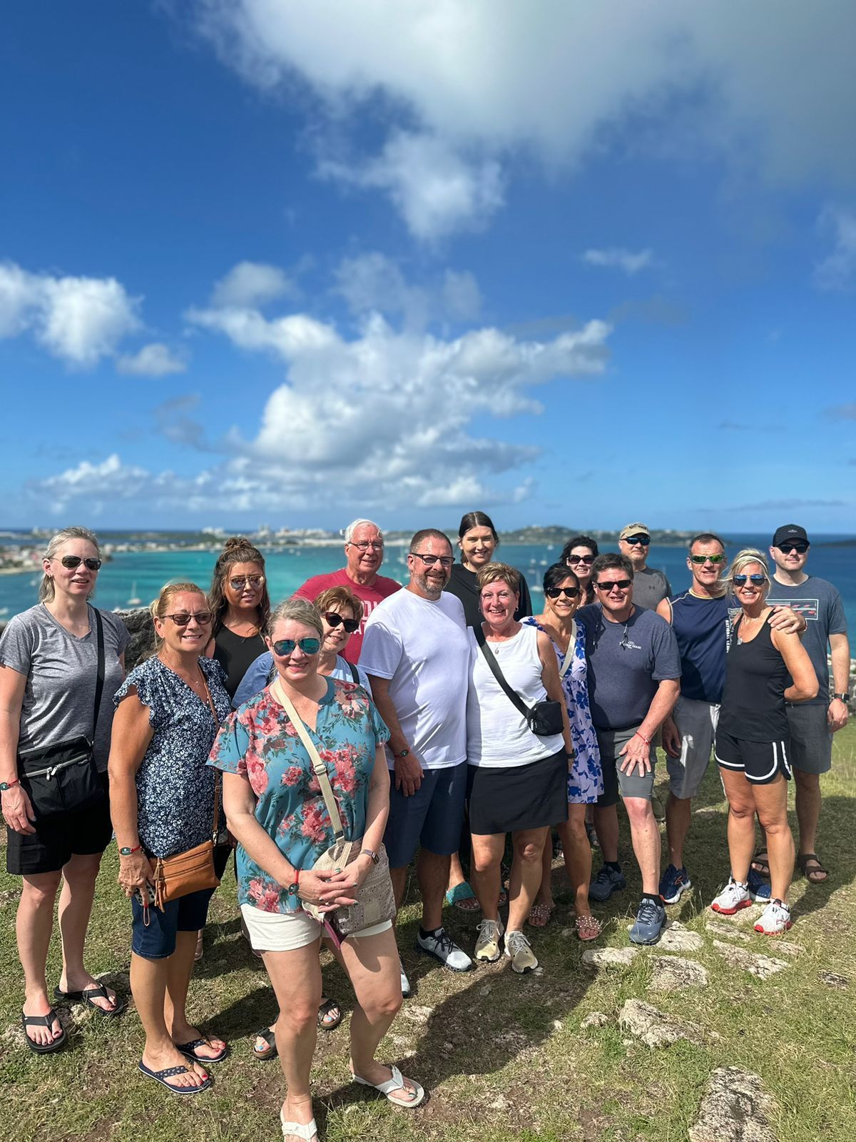 A group of people are posing for a picture in front of the ocean.